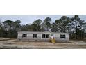 Beige manufactured home with black shutters and a wooden staircase at 126 Addison Rd, Harleyville, SC 29448