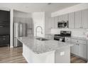 Modern kitchen with gray cabinets, granite island, and stainless steel appliances at 134 Vistawood Dr, Charleston, SC 29414