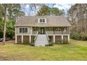Two-story house with a wraparound porch and spacious lawn at 1575 Tacky Point Rd, Wadmalaw Island, SC 29487