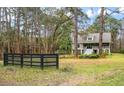 House exterior view with a black fence in the foreground at 1575 Tacky Point Rd, Wadmalaw Island, SC 29487