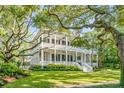 Two story home with wrap around porch and mature landscaping at 1750 Ion Ave, Sullivans Island, SC 29482