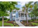 Beautiful blue house with lush landscaping and white porch at 2433 Louisville St, Charleston, SC 29492