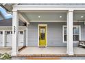 Inviting front porch with yellow door and porch swing at 327 Great Lawn Dr, Summerville, SC 29486