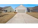 Long driveway leading to a gray house and garage at 487 Switchgrass Dr, Summerville, SC 29486