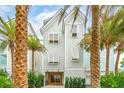 Two-story beach home with white siding, shutters, and a paved driveway at 58 Grand Pavilion Blvd, Isle of Palms, SC 29451