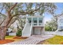 Two-story light blue house with white trim, a front porch, and a landscaped yard at 1442 Eutaw Battalion Dr, Charleston, SC 29412