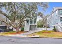 Two-story light blue house with white trim, a front porch, and a landscaped yard at 1442 Eutaw Battalion Dr, Charleston, SC 29412
