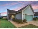 One-story home with light blue siding, attached garage, and nicely landscaped yard at 310 Bloomington Way, Summerville, SC 29486