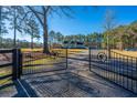 Ornate black metal gates open to reveal a charming house at 490 Cummings Chapel Rd, Ridgeville, SC 29472