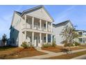 Two-story white house with front porch, landscaping, and sidewalk at 507 N Commodore Way, Summerville, SC 29483
