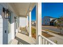 Bright front porch with white columns and railing, and street view at 507 N Commodore Way, Summerville, SC 29483