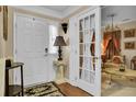Bright entryway with hardwood floors, white door, and sitting area at 9185 Parlor Dr, Ladson, SC 29456