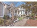 House exterior showcasing a charming front porch and neatly landscaped yard at 216 Bumble Way, Summerville, SC 29485