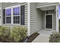 Front entrance with black door and gray siding at 484 Whispering Breeze Ln, Summerville, SC 29486