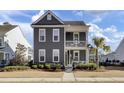 Two-story gray house with white accents, front porch, and landscaped yard at 703 N Hickory St, Summerville, SC 29483