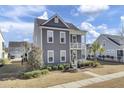 Two-story gray house with white accents, front porch, and landscaped yard at 703 N Hickory St, Summerville, SC 29483