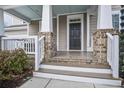 Front porch with brick columns, white railings, and dark brown door at 705 Quintan St, Summerville, SC 29486