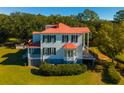 Two-story home with red roof, large yard, and lush trees at 927 Fishburne Rd, Pinopolis, SC 29469