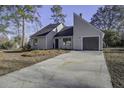 Gray house with a large driveway and mature trees at 117 Hummingbird Ave, Ladson, SC 29456