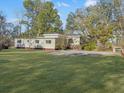Back of house with large grassy yard and mature trees at 138 Green Pond Hwy, Walterboro, SC 29488