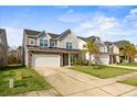 Two story house with gray siding, stone accents, and a two-car garage at 187 Weeping Cypress Dr, Moncks Corner, SC 29461
