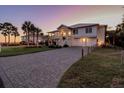 Evening view of a two-story home with a brick driveway and landscaping at 3 43Rd Ave, Isle of Palms, SC 29451