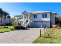 Two-story home with white siding, metal roof, and a brick driveway at 3 43Rd Ave, Isle of Palms, SC 29451