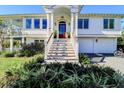 Two-story home with a wooden staircase and a double-door entryway at 3 43Rd Ave, Isle of Palms, SC 29451
