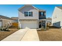 Two-story house with gray and beige siding, a white garage door, and landscaping at 307 Black Birch Dr, Summerville, SC 29486