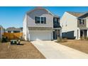 Two-story house with gray and beige siding, a white garage door, and landscaping at 307 Black Birch Dr, Summerville, SC 29486