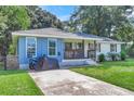 Cute one-story home with blue and white exterior, covered porch, and well-manicured lawn at 5242 Potomac St, North Charleston, SC 29405