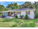 Attractive one-story home with blue and white exterior, covered porch, and lush landscaping at 5242 Potomac St, North Charleston, SC 29405