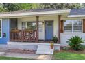 Quaint front porch with blue door, wooden railing, and colorful flower boxes at 5242 Potomac St, North Charleston, SC 29405