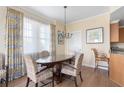 Elegant dining room with a glass-top table and four chairs, hardwood floors, and large windows at 5804 Palmetto Dr # A-201/203, Isle of Palms, SC 29451