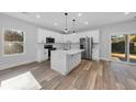 Modern kitchen with white cabinets, stainless steel appliances, and an island at 5889 N Rhett Ave, Hanahan, SC 29410