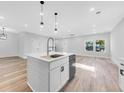 Modern kitchen with white cabinets, stainless steel appliances, and an island at 5889 N Rhett Ave, Hanahan, SC 29410