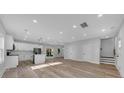 Open floor plan with hardwood floors, white cabinets, and an island at 5889 N Rhett Ave, Hanahan, SC 29410