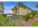 Building exterior showcasing ample parking and landscaping at 1400 Ocean Blvd # 104-A, Isle of Palms, SC 29451