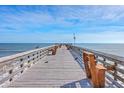 Ocean pier with benches offering scenic ocean views at 1400 Ocean Blvd # 104-A, Isle of Palms, SC 29451