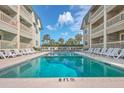Community pool with lounge chairs, offering a relaxing space at 1400 Ocean Blvd # 104-A, Isle of Palms, SC 29451