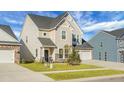 Two-story house with beige siding, a two-car garage, and landscaped front yard at 149 Cypress Preserve Blvd, Moncks Corner, SC 29461