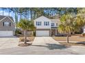 Two story house with brick and siding, two palm trees, and a two-car garage at 2700 Sunrose Ln, Johns Island, SC 29455