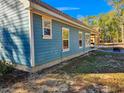 Side view of a light blue house showcasing its siding and windows at 273 Plantation Ln, Walterboro, SC 29488