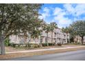 Three-story peach building with white trim and balconies on a tree-lined street at 2978 Sugarberry Ln, Johns Island, SC 29455