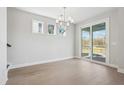 Bright dining room with hardwood floors, chandelier, and sliding glass doors to patio at 299 Claret Cup Way, Charleston, SC 29414