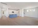 Open concept kitchen with island, white cabinets, and hardwood floors at 299 Claret Cup Way, Charleston, SC 29414