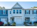 Two-story townhome with gray and white siding, two-car garage, and landscaping at 553 Trotters Ln, Moncks Corner, SC 29461