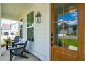 Front porch with wooden door and two black adirondack chairs at 780 Opal Wing St, Moncks Corner, SC 29461