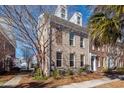 Brick townhouse with American flags, landscaping, and walkway at 826 Rue Dr, Charleston, SC 29414