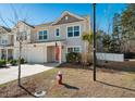 Two-story townhome with gray siding, red door, and American flag at 9761 Transplanter Cir, Ladson, SC 29456